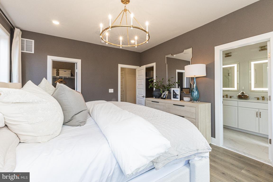 11652 American Dream Way Reston, VA 20190 - Photo 22 of 51 a spacious bedroom with a large bed and chandelier