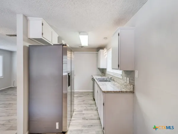 a kitchen with stainless steel appliances granite countertop a refrigerator and a sink