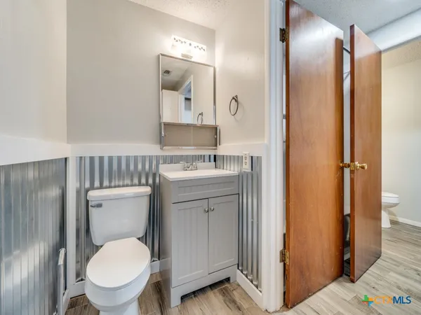 a bathroom with a toilet a sink and mirror