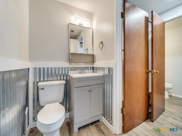 a bathroom with a toilet a sink and mirror