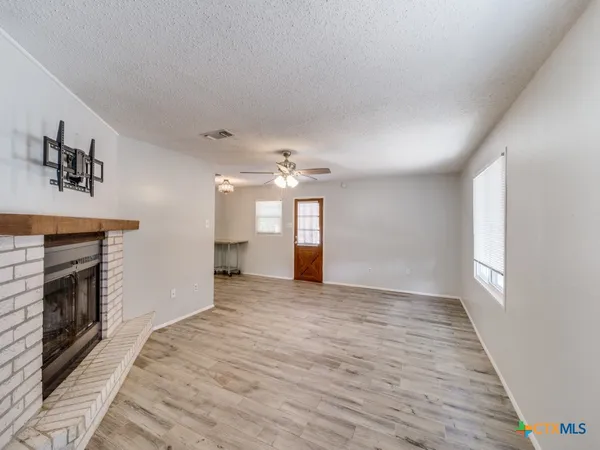 wooden floor fireplace and windows in an empty room