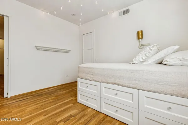 a spacious bedroom with a bed and a dresser