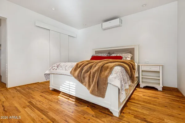 a bedroom with a bed and wooden floor