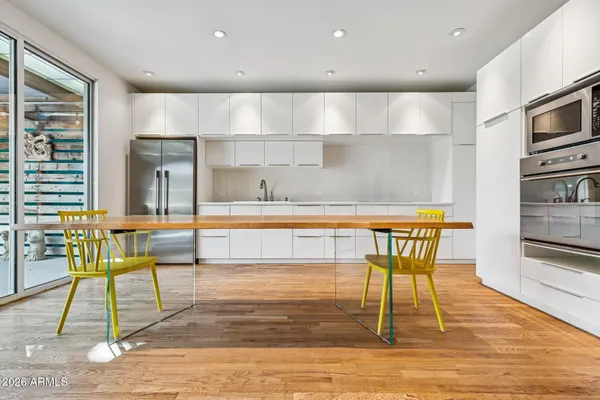 a kitchen with kitchen island granite countertop a stove a sink and a dining table view