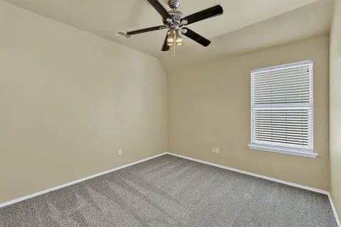 an empty room with a window and a fan