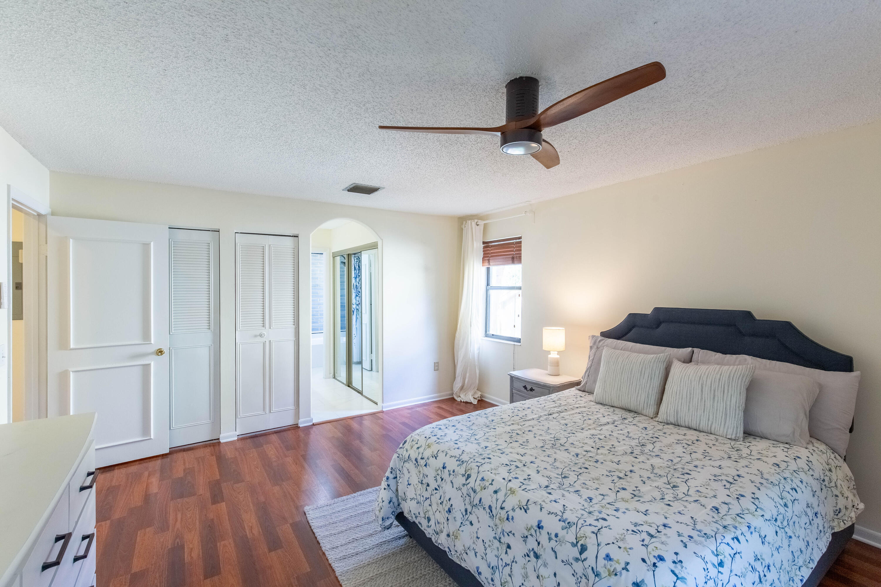 13165 Chadwick Court, Unit 32 Wellington, FL 33414 - Photo 20 of 25 a bedroom with a large bed and wooden floor