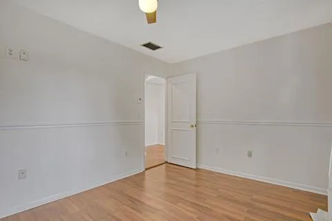 an empty room with wooden floor and window