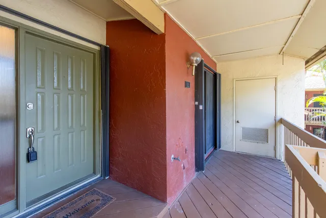 a view of a hallway with wooden floor and a bathroom