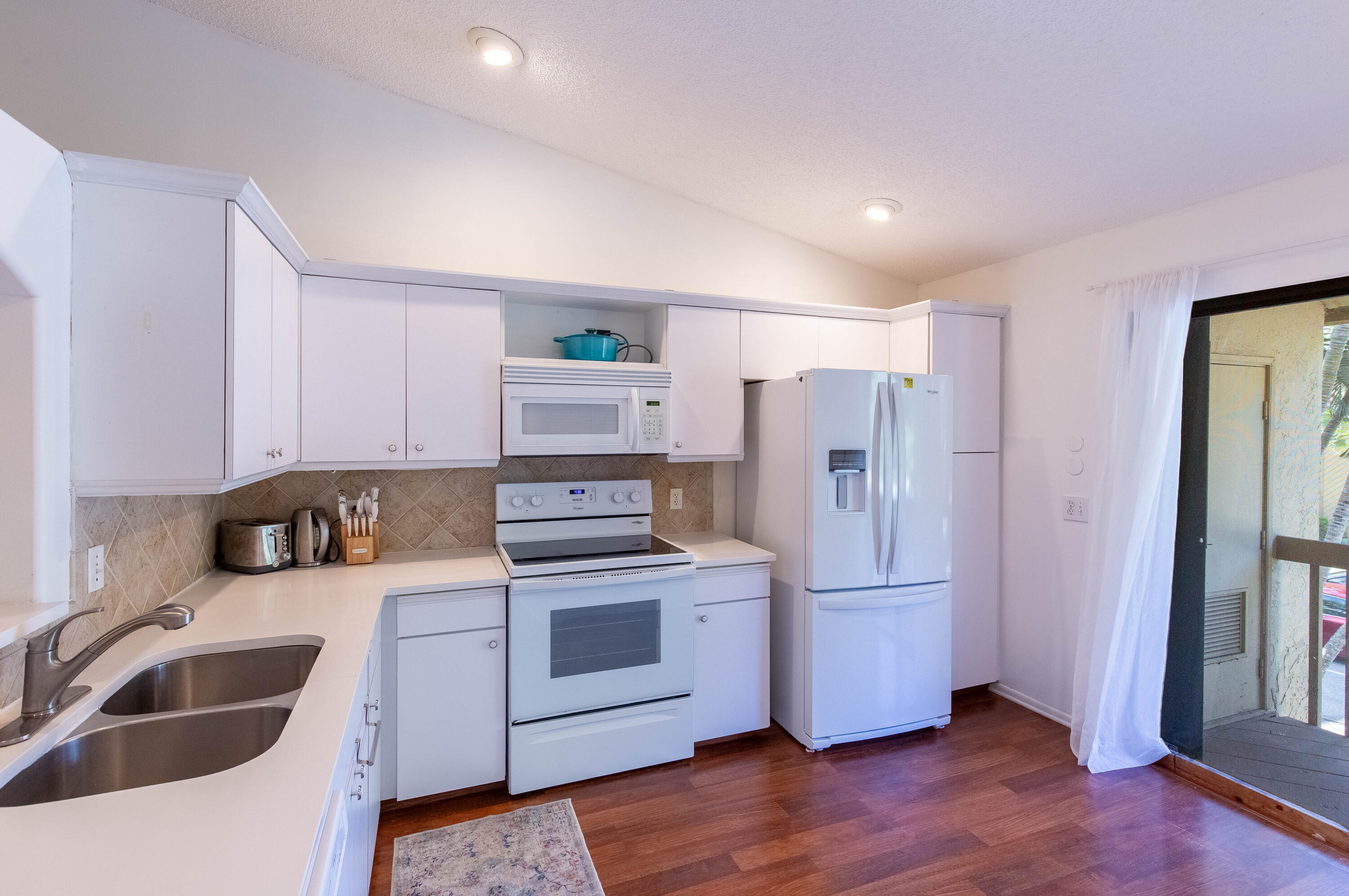 13165 Chadwick Court, Unit 32 Wellington, FL 33414 - Photo 9 of 25 a kitchen with a refrigerator sink and cabinets