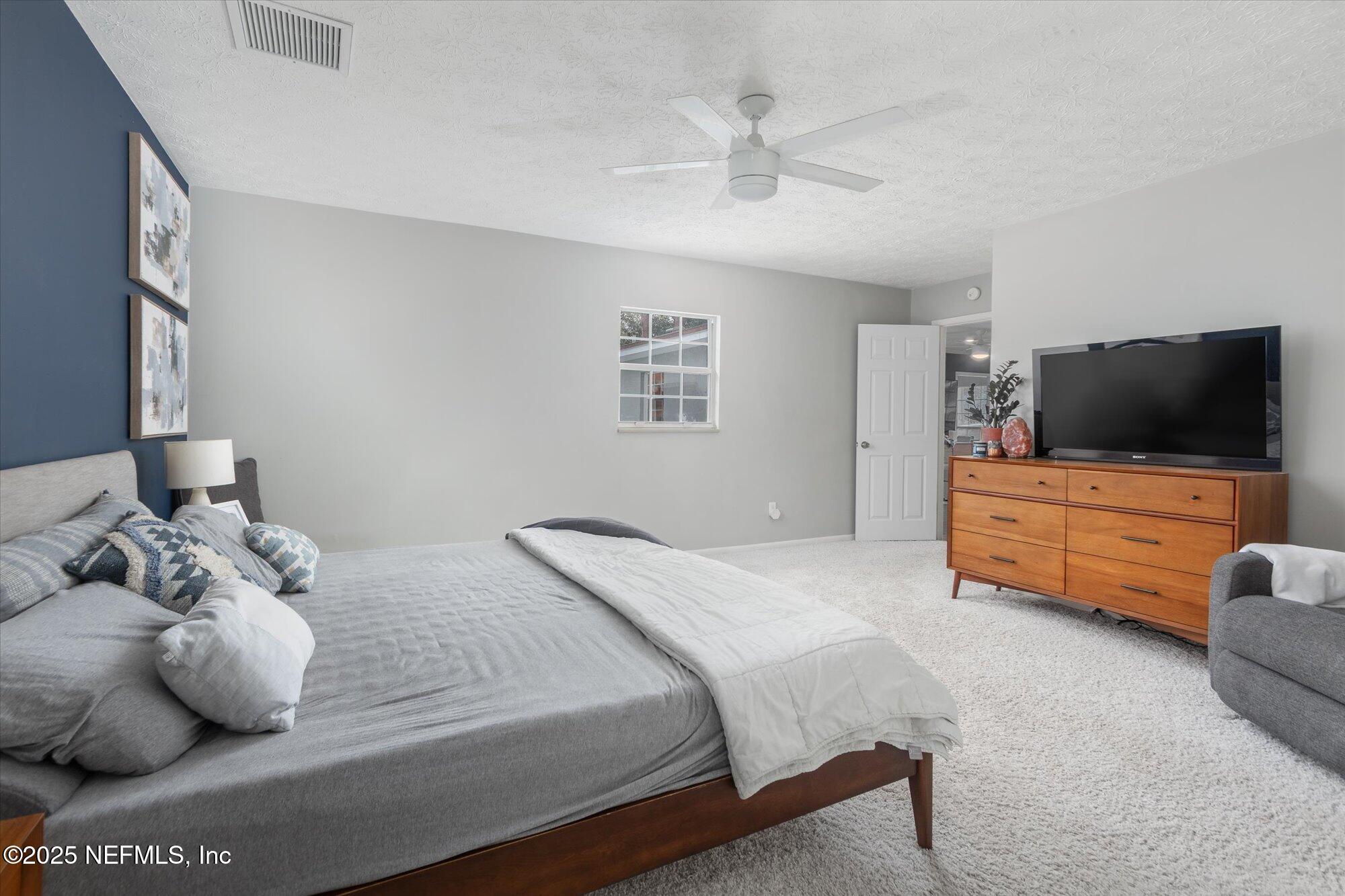 939 Grove Park Drive North Orange Park, FL 32073 - Photo 41 of 57 a bedroom with a bed and flat screen tv