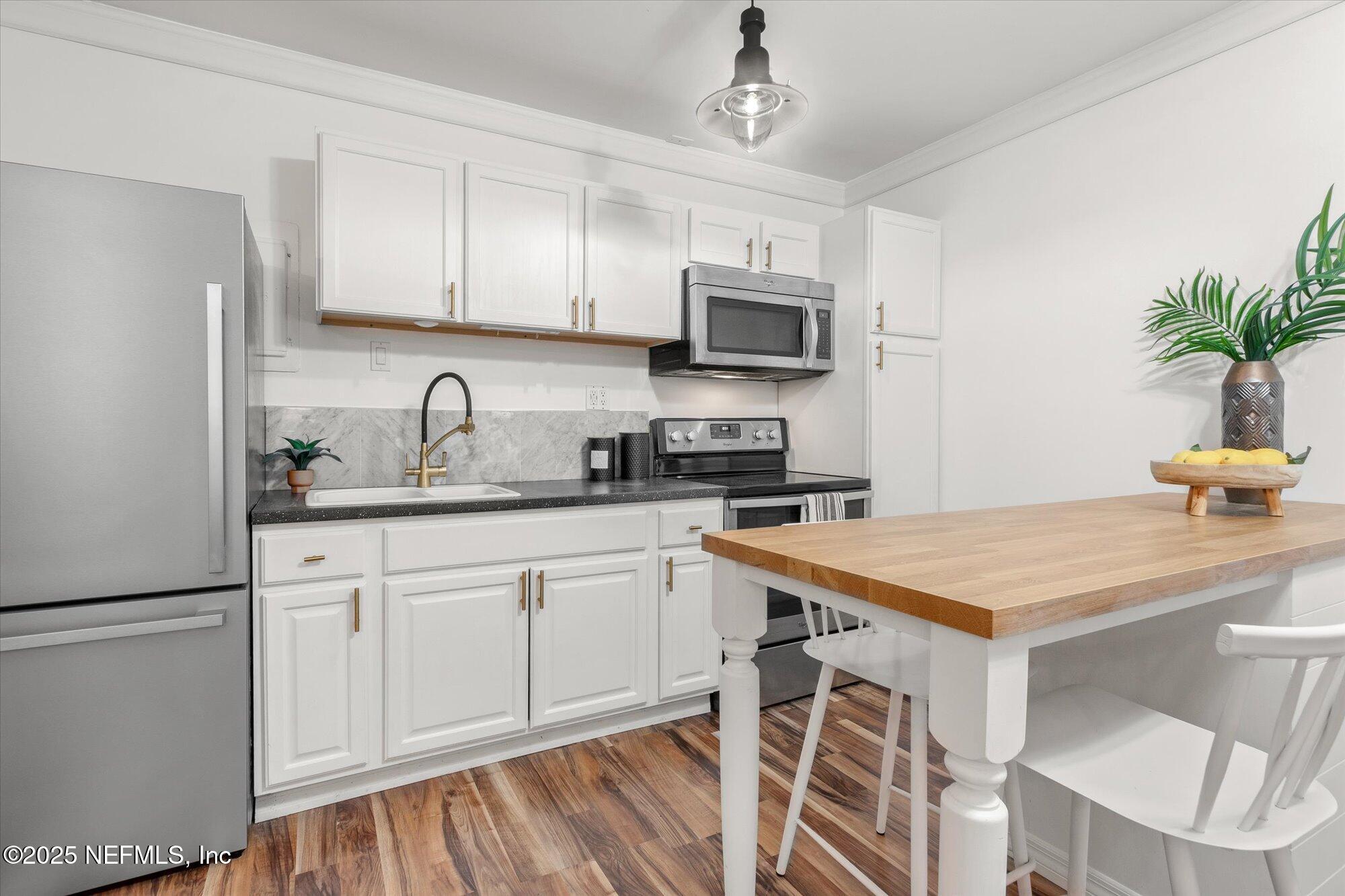 939 Grove Park Drive North Orange Park, FL 32073 - Photo 45 of 57 a kitchen with white cabinets stainless steel appliances and a sink