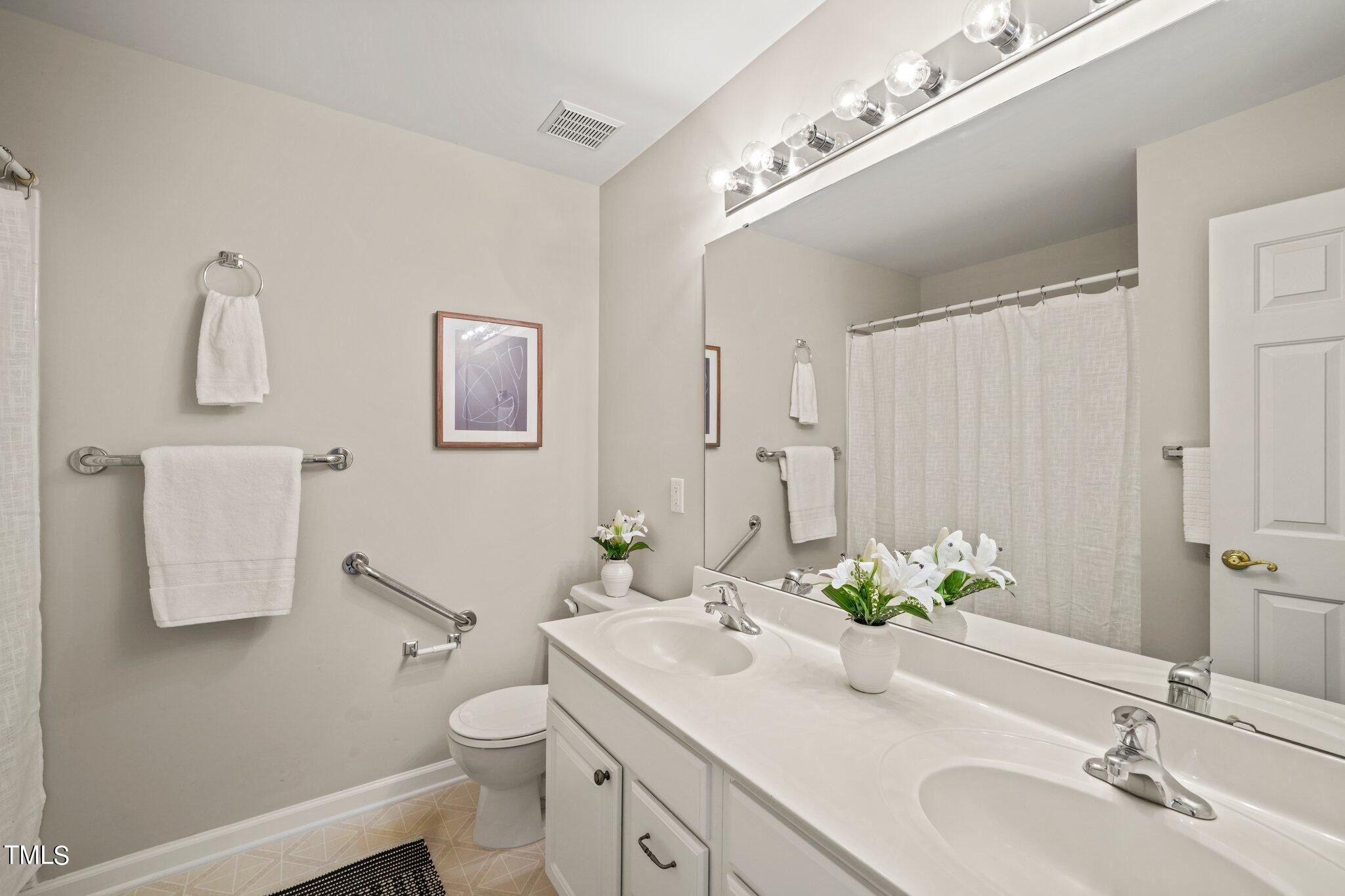 5325 Echo Ridge Road Raleigh, NC 27612 - Photo 30 of 61 a bathroom with a granite countertop sink a toilet and a mirror