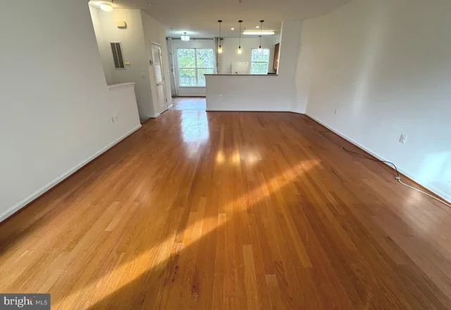 a view of an empty room and a kitchen