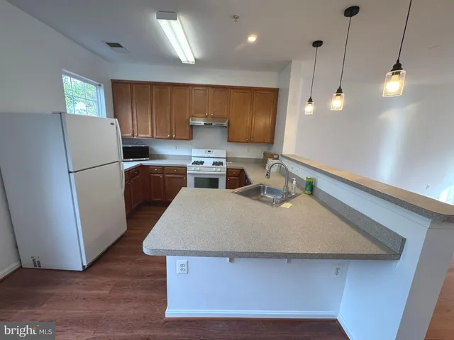 a kitchen with a sink a refrigerator and a stove