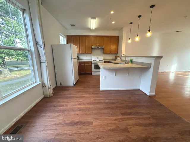 a view of a kitchen with a sink and refrigerator