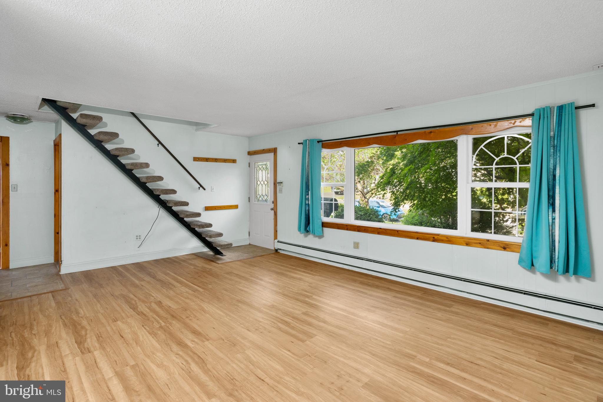 23 Cotton Road Levittown, PA 19057 - Photo 5 of 36 a view of an empty room with wooden floor and a window