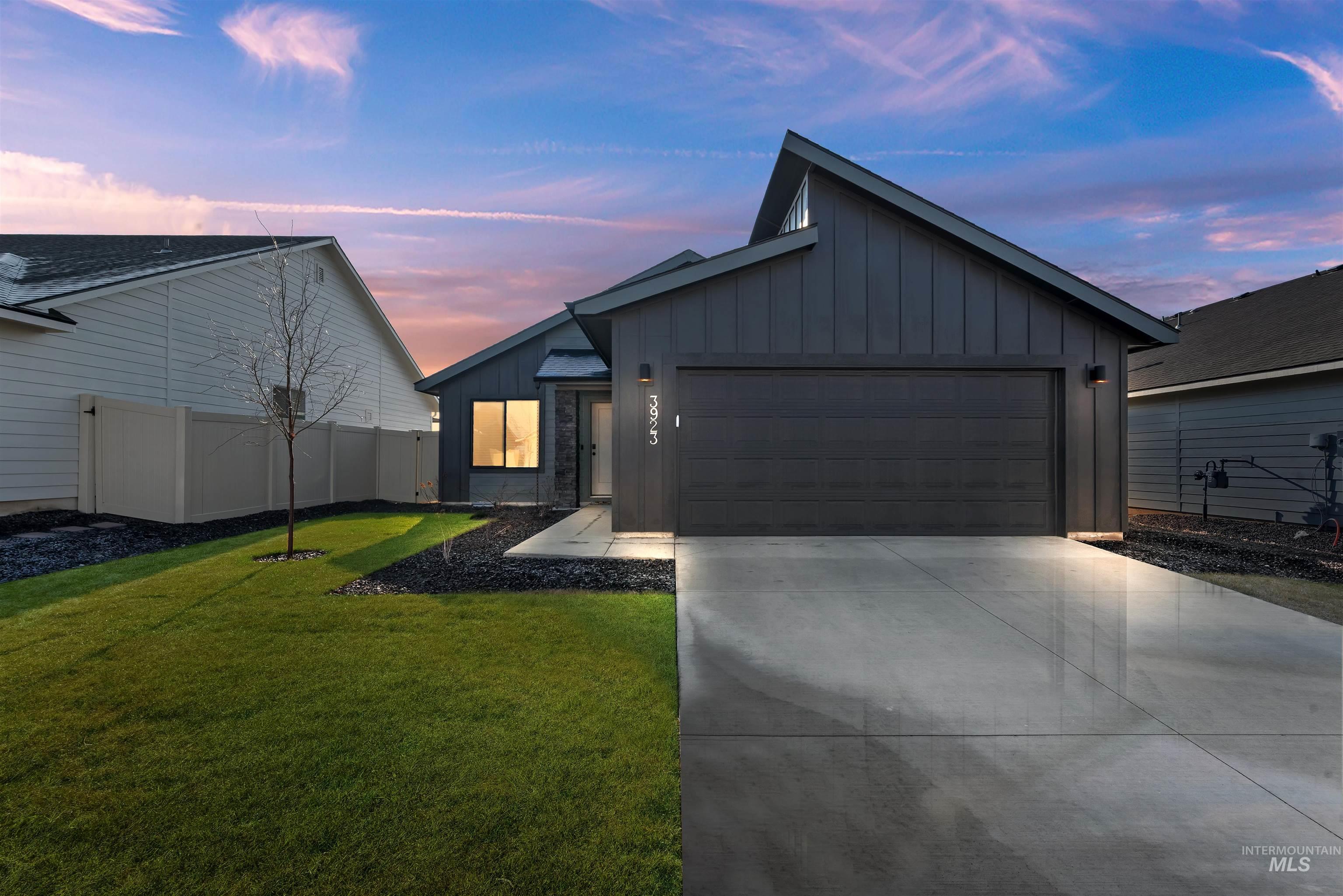 View of front of house with board and batten siding, concrete driveway, and a garage