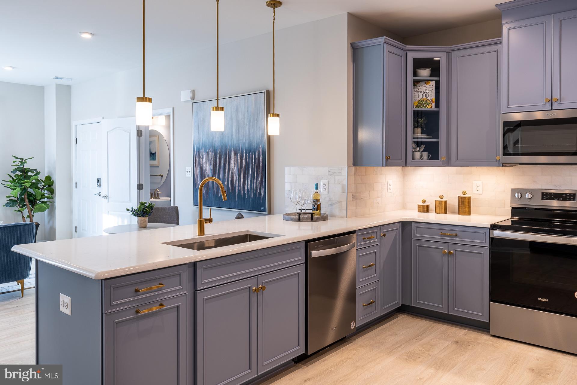 a kitchen with a sink dishwasher and a stove with wooden floor
