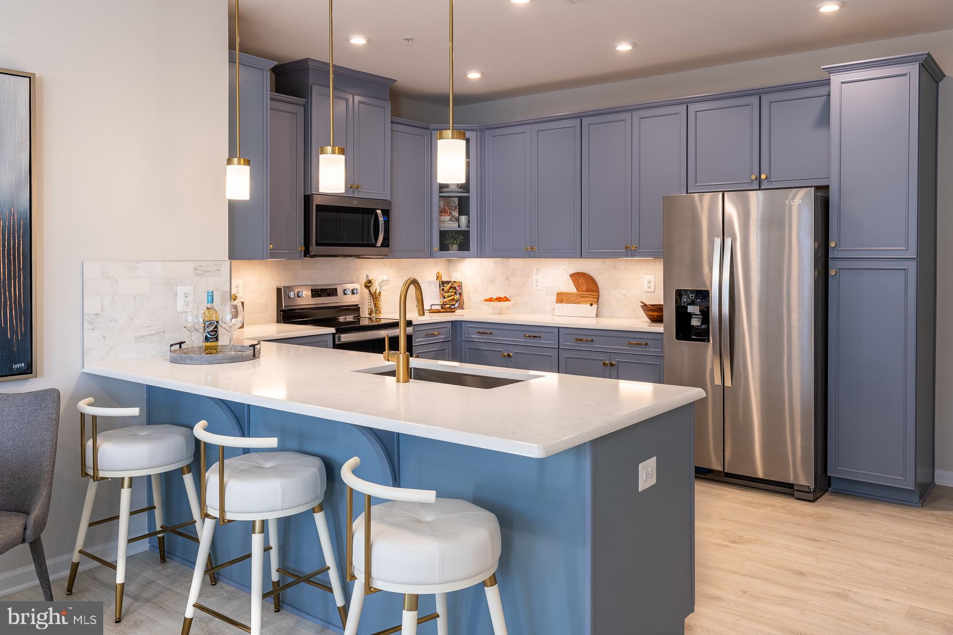 9982 A Justify Run Laurel, MD 20723 - Photo 3 of 11 a kitchen with a table chairs refrigerator and microwave