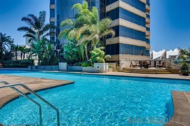 a swimming pool with barbeque oven and palm trees