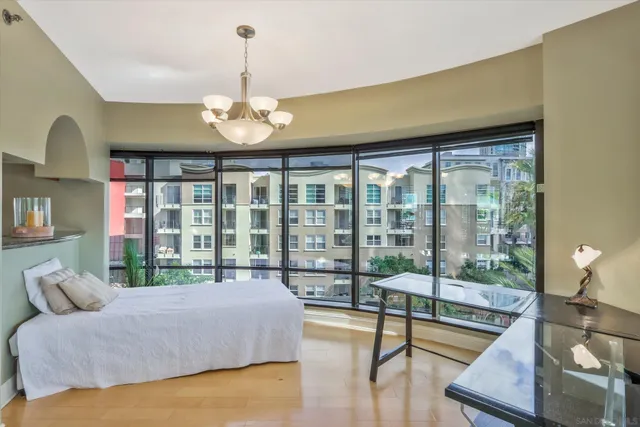 a spacious bedroom with a large bed and a chandelier