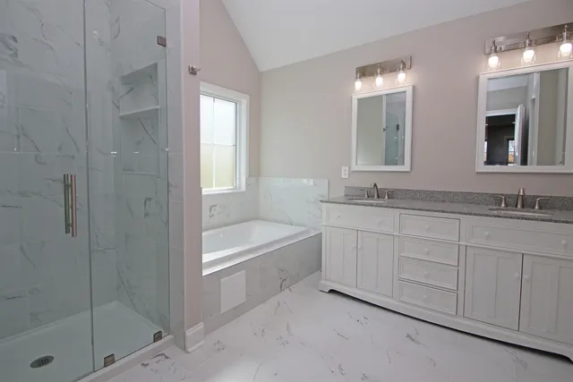 a bathroom with a granite countertop bathtub shower sink and mirror