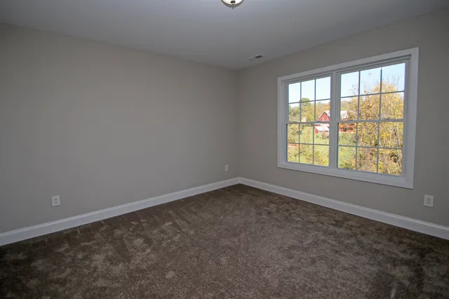 an empty room with closet and mirror