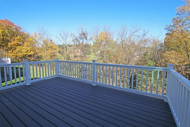 a view of a balcony with wooden floor and fence