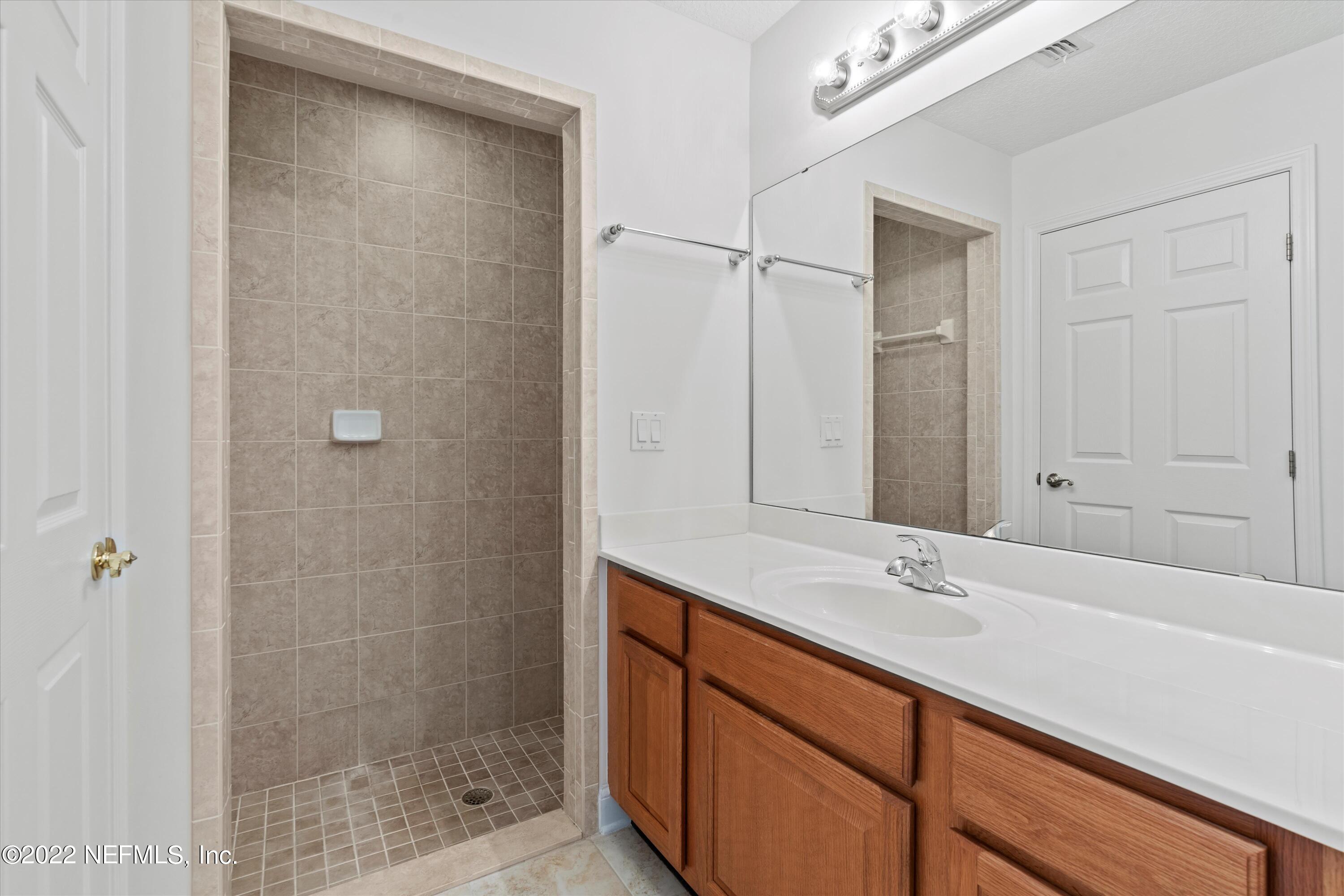 5306 Eulace Road Jacksonville, FL 32210 - Photo 15 of 30 a bathroom with a shower sink and vanity