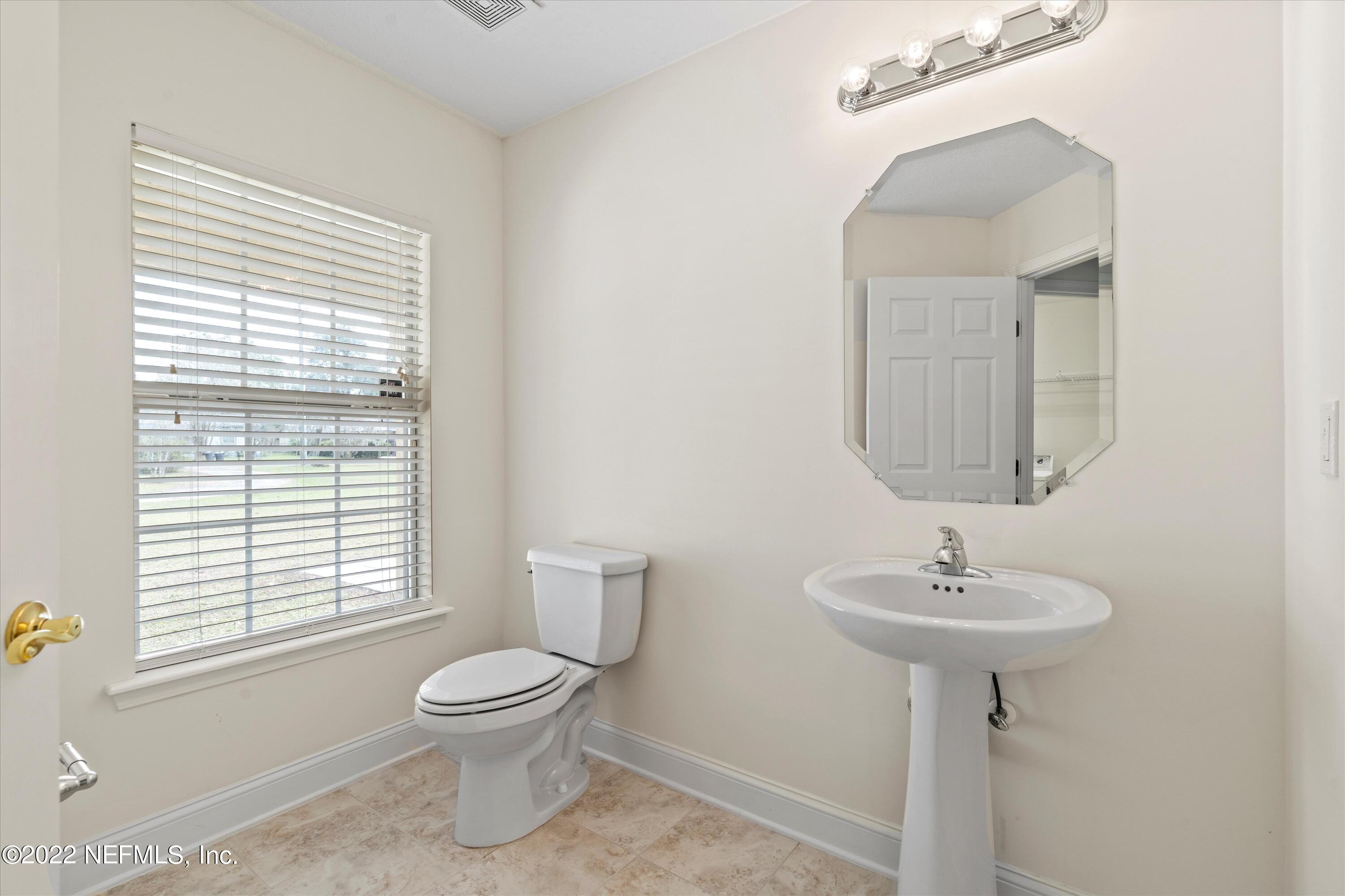 5306 Eulace Road Jacksonville, FL 32210 - Photo 20 of 30 a bathroom with a toilet a sink a window and mirror