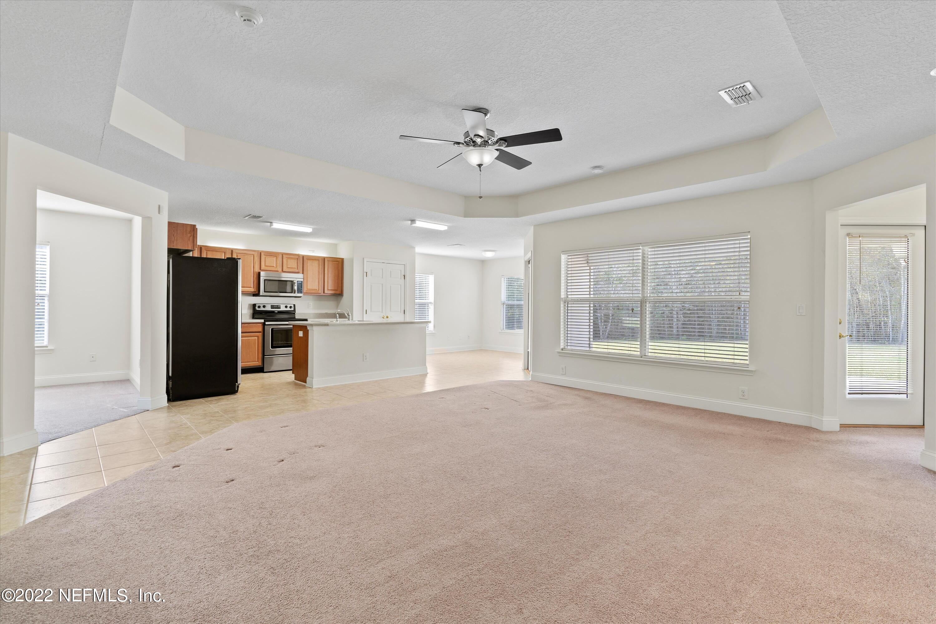 5306 Eulace Road Jacksonville, FL 32210 - Photo 8 of 30 a view of an empty room with a window and a kitchen