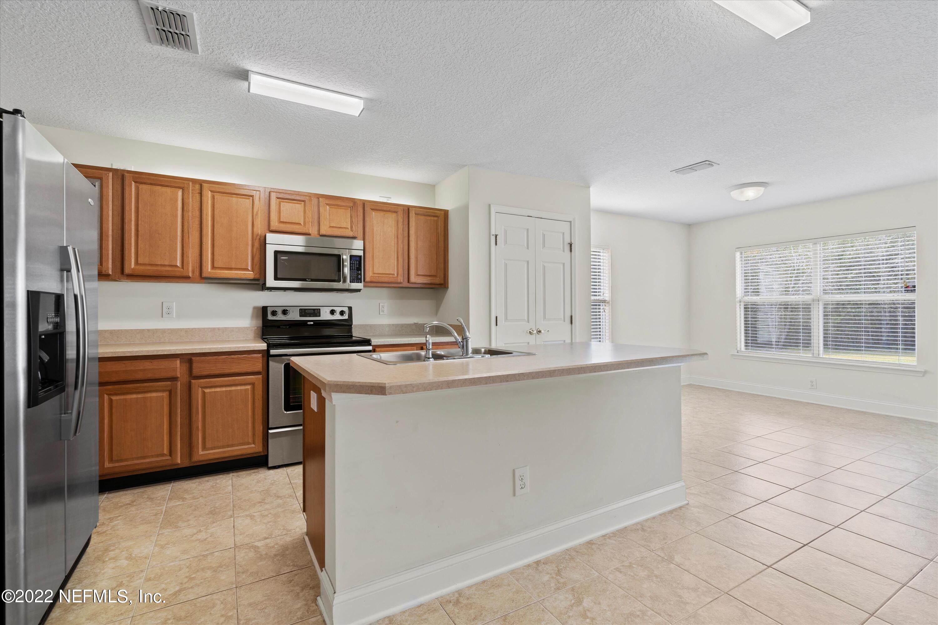 5306 Eulace Road Jacksonville, FL 32210 - Photo 9 of 30 a kitchen with stainless steel appliances granite countertop a stove top oven a sink dishwasher and a microwave oven on the blue kitchen countertops
