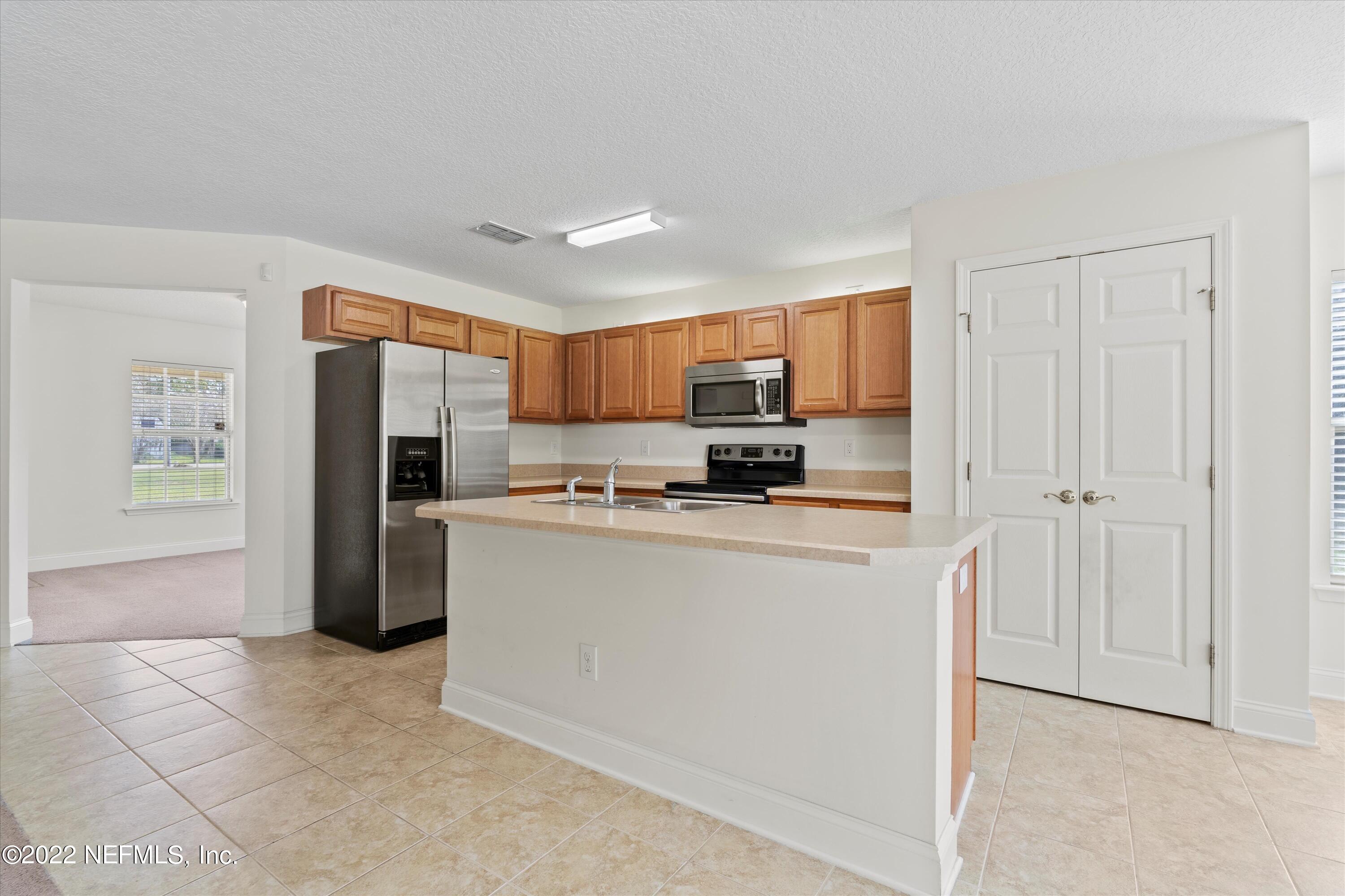 5306 Eulace Road Jacksonville, FL 32210 - Photo 10 of 30 a kitchen with stainless steel appliances granite countertop a refrigerator and a stove top oven