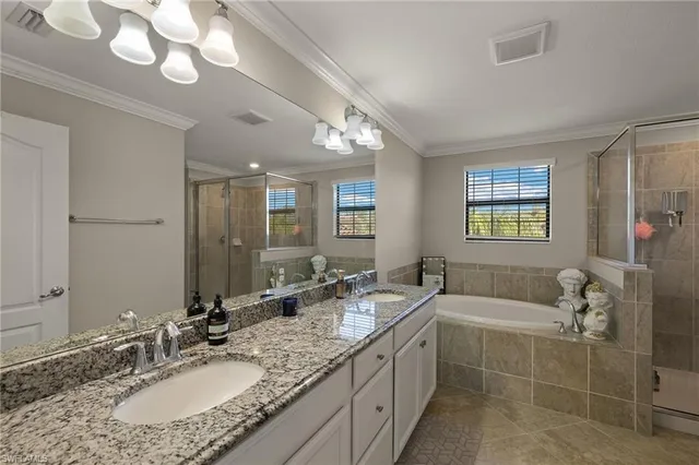 a bathroom with a granite countertop double vanity sink a mirror and a shower