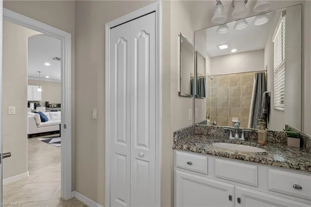 a bathroom with a granite countertop sink a mirror and shower