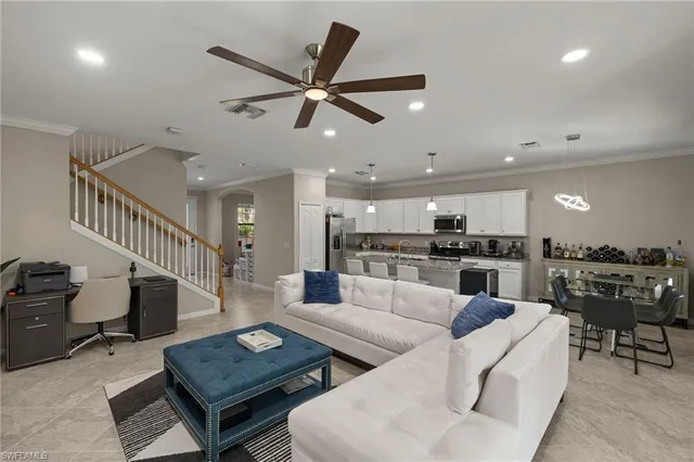 a living room with furniture and a view of kitchen