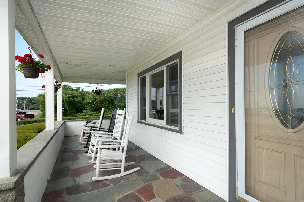 65 Jericho Road Scituate, MA 02066 - Photo 8 of 26 a porch area with a table and chairs