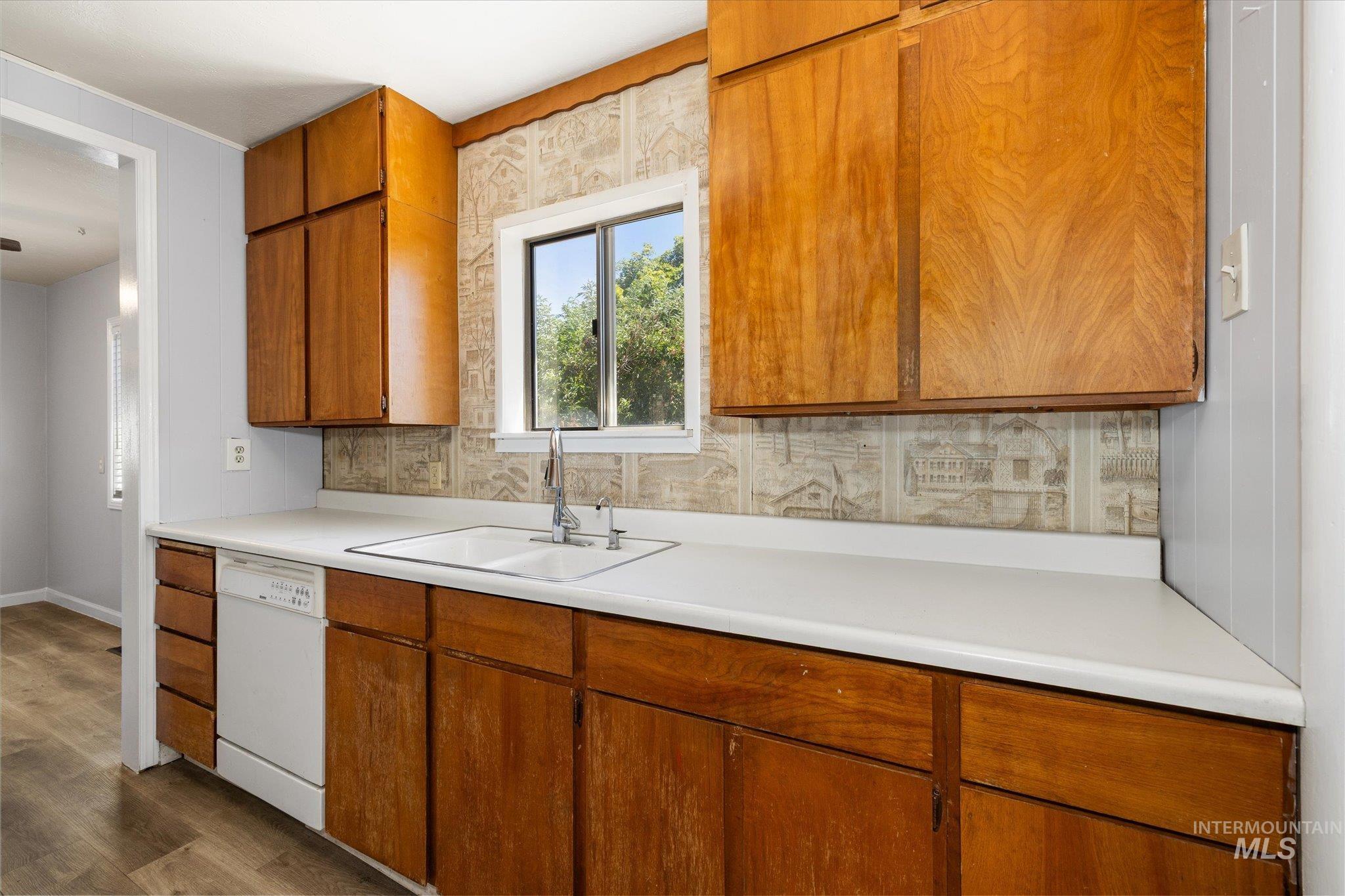 918 West 3rd Street Weiser, ID 83672 - Photo 18 of 36 Kitchen featuring wood cabinetry, white countertops, a double-basin sink with a chrome faucet, and a built-in dishwasher