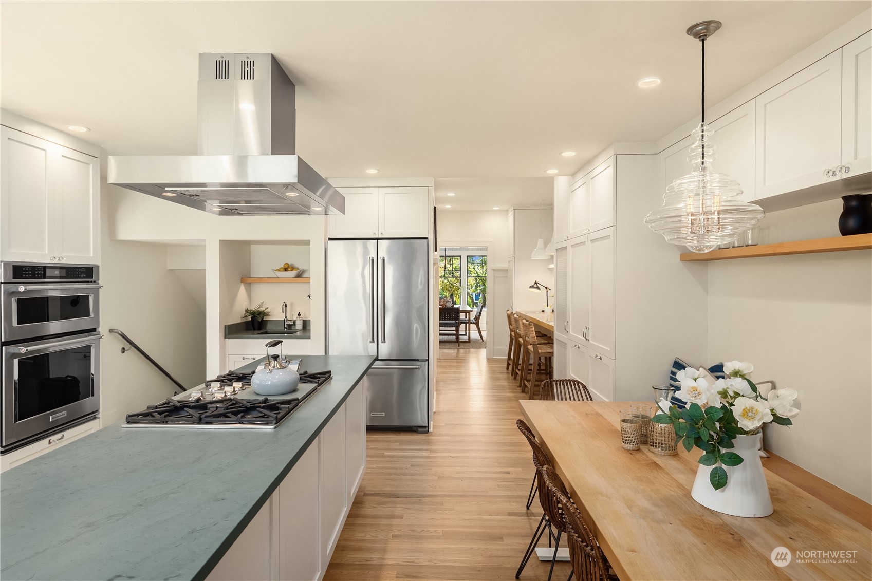 2536 1st Avenue West Seattle, WA 98119 - Photo 10 of 27 a open kitchen with stainless steel appliances kitchen island granite countertop a table chairs in it and wooden floors