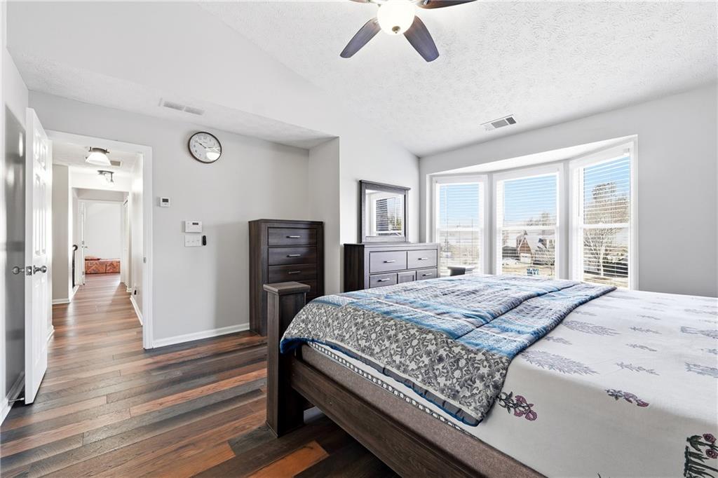 2964 Abbotts Oak Way Duluth, GA 30097 - Photo 21 of 29 a bedroom with a bed and wooden floor