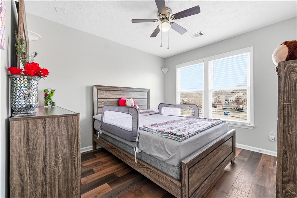 2964 Abbotts Oak Way Duluth, GA 30097 - Photo 26 of 29 a bedroom with a bed and a chandelier