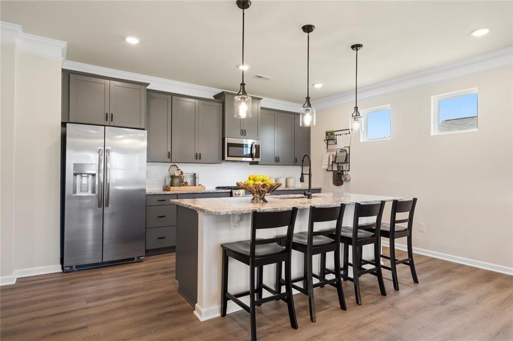 80 Cove Road Ringgold, GA 30736 - Photo 8 of 37 a kitchen with stainless steel appliances kitchen island granite countertop a dining table chairs and white cabinets