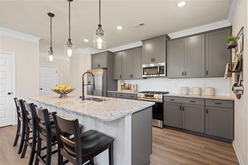 80 Cove Road Ringgold, GA 30736 - Photo 10 of 37 a kitchen with stainless steel appliances granite countertop a sink a stove a kitchen island with chairs and wooden floor