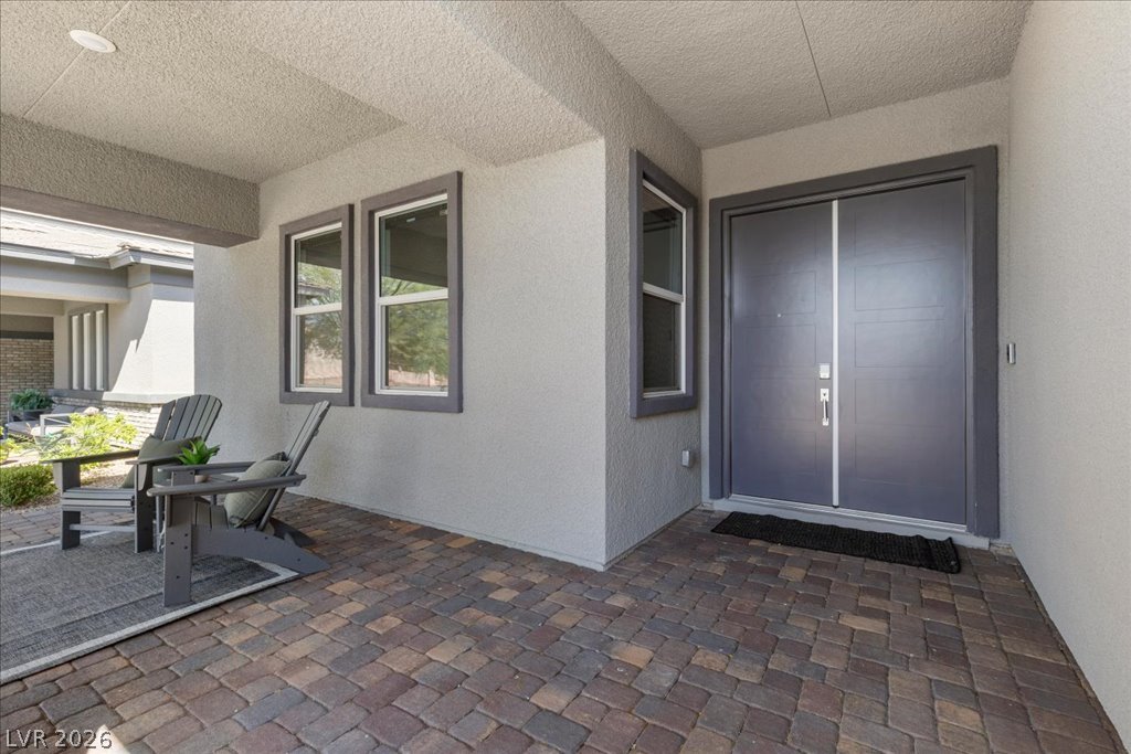 20 Charlotte Ridge Place Henderson, NV 89011 - Photo 2 of 33 A welcoming front entrance with double doors, a covered patio and paved walkway.