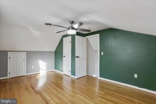a view of empty room with wooden floor