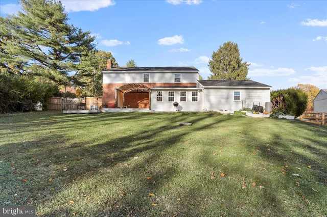 a view of a house with a big yard and large trees