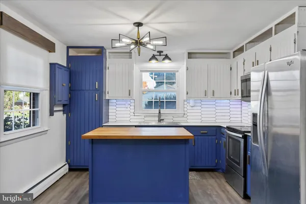 a kitchen with stainless steel appliances granite countertop a sink refrigerator and cabinets
