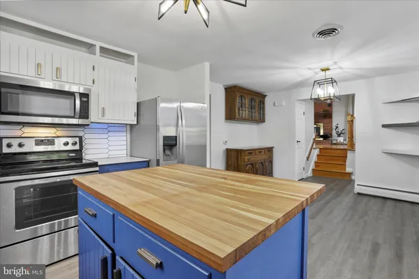 a kitchen with a stove a refrigerator and a microwave