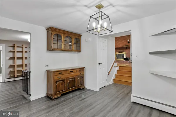 a view of a livingroom with wooden floor staircase and a kitchen