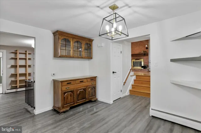 a view of a livingroom with wooden floor staircase and a kitchen